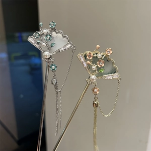 Macro view of Chinese fan hairpins featuring enamel flowers, pearls and flowing tassels