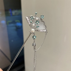 Detail of silver fan-shaped hair pin with blue enamel flowers and dangling tassels