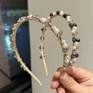 Detailed close-up of handmade headbands featuring white pearls and faceted crystal beads