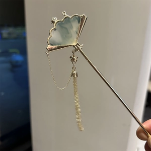 Macro detail of ancient style tassel hair pin with fan shape and jade texture