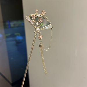 Close-up of golden folding fan hairpin with pink flowers, pearls and tassel detail