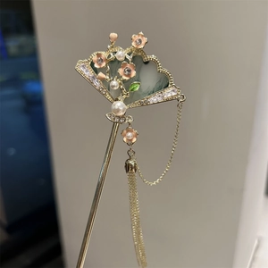 Detail of a vintage Chinese gold fan hair stick with emerald resin and pearl tassels
