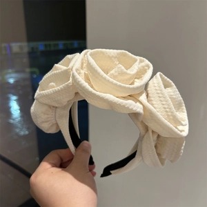 Detailed view of handmade cream fabric headband with three layered 3D rose flowers