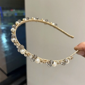 Detail of vintage headband featuring faux pearls, crystals and gold coiled beads decoration