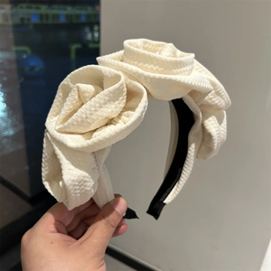 Detail of white fabric headband featuring three large handcrafted 3D roses in vintage style