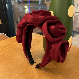 Detailed macro view of dark red fabric rose headband with vintage textured 3D flower petals