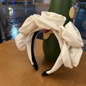 Detailed view of layered white fabric rose petals on an elegant 3D floral headband
