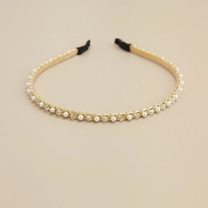 Détails du serre-tête doré orné de perles blanches, de cristaux et d'embouts noirs doux