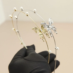 Detailopname van gouden en zilveren barokke haarbanden met parels en vlinderdecoratie in metaal