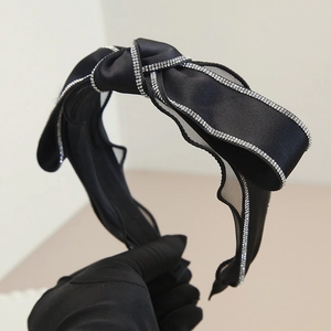 Elegante cerchietto in raso nero con un fiocco scintillante impreziosito da strass