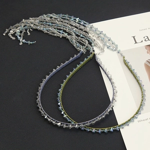 Detail of handmade beaded headband featuring crystal tassels and gradient metallic chains