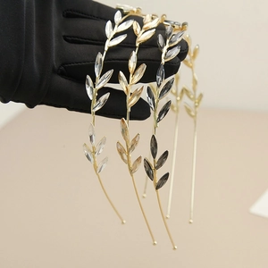 Detailed view of rhinestone leaf headbands in gold metal with champagne and gray crystals