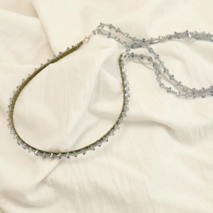 Macro detail of handmade beaded choker with vintage green cord and blue crystal beads