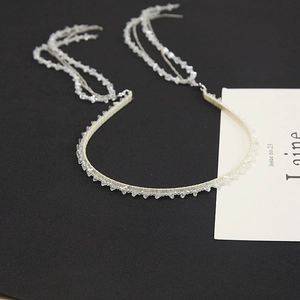 Detail of crystal headband with long beaded fringe tassels on a black background