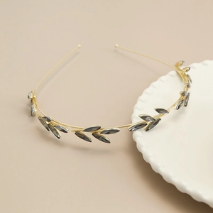 Detailed macro shot of vintage gold metal headband with grey marquise crystal leaf motifs