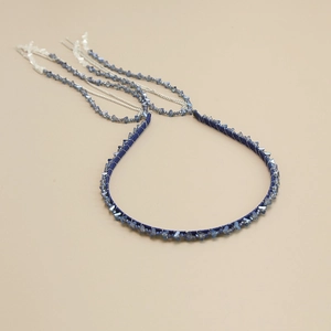 Detail of handcrafted blue crystal bead headband with silver fringe and woven texture