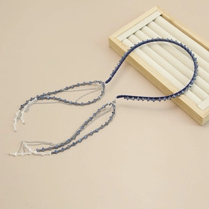 Detailed shot of handmade beaded headband with hanging blue crystal tassels and silver chains