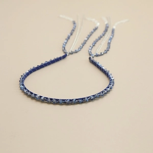 Detail of dark blue beaded headband featuring crystal fringe and silver metal chain tassels