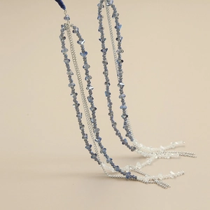 Detail of handmade beaded headband featuring blue gradient crystals and long tassels