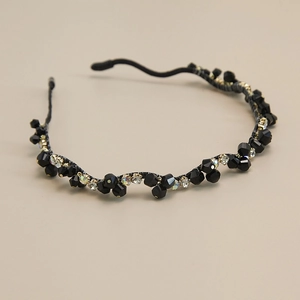 Détail d'un serre-tête baroque avec perles noires multifacettes et strass colorés brillants
