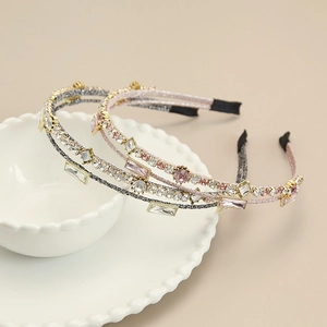 Detail view of handmade crystal headbands with double-row rhinestones on a ceramic bowl