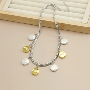 Detail of double-layer silver chain with baroque pearls and gold embossed letter charms