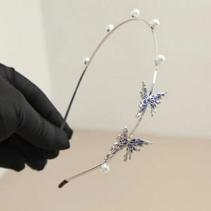 Detailed macro view of silver butterfly headband with blue enamel and white pearls