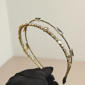 Detail of elegant double-layered headband with white rhinestones and gray crystals on gold base
