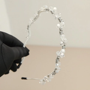 Macro détaillée d'un serre-tête ondulé en perles de cristal avec monture en métal argenté