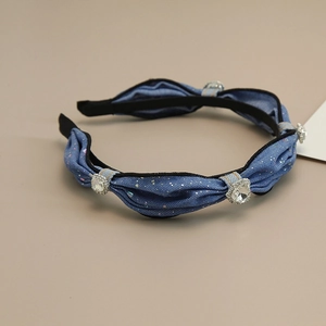 Detailed close-up of blue denim headband with sparkling crystals and silver rhinestone accents