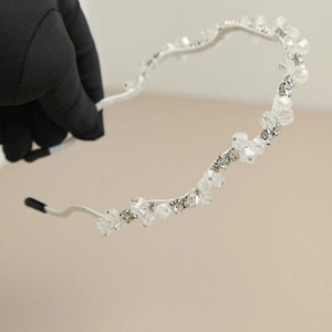 Détail du serre-tête argenté avec cristaux facettés et strass brillants