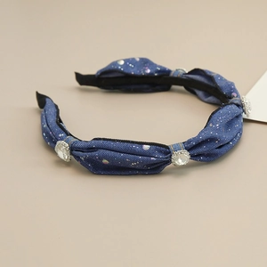 Detailed view of dark blue denim headband with sparkling sequins and three large rhinestones