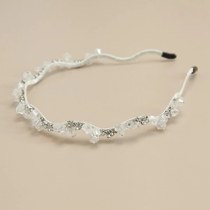 Détail de perles en cristal sur un serre-tête ondulé argenté avec tissage délicat