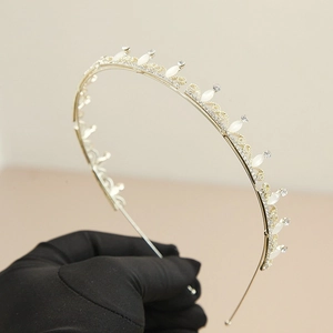 Eleganter goldener Haarreif mit weißen Katzenaugensteinen und glänzenden Strasssteinen für Bräute