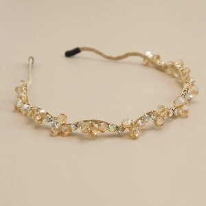 Détail du serre-tête en cristal champagne avec fil doré et strass étincelants
