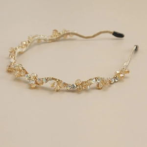 Détail du serre-tête doré champagne avec perles de cristal facettées et des strass