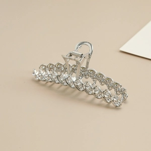 Detail shot of silver metal shark hair claw clip with sparkling rhinestones and woven design