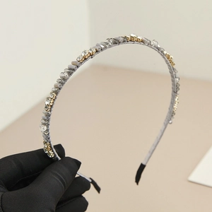 Détail d'un serre-tête en cristal gris avec strass sur une base en métal doré élégant