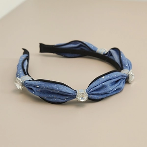Detailed macro view of denim headband featuring sparkling rhinestones and fabric folds