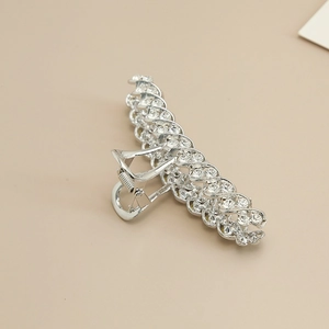 Detail of silver alloy hair claw clip featuring sparkling rhinestones and woven texture