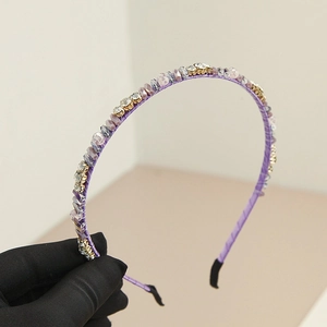 Gros plan d'un serre-tête perlé violet avec cristaux brillants et finition satin