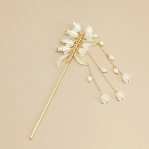 Detail of elegant lily of the valley hair pin with golden tassels and delicate flower buds