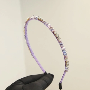 Vue détaillée d'un serre-tête en cristal violet avec strass posés à la main