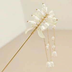Close-up of lily of the valley hair pin with pearls and golden hanging tassels