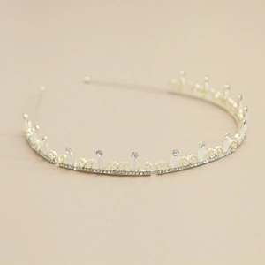 Detailansicht eines eleganten goldfarbenen Haarreifs mit Strass und Perlenanhängern