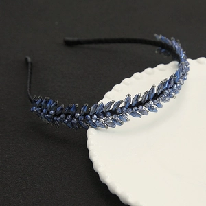 Détail des perles en cristal bleu et du motif de plumes sur le bandeau de luxe