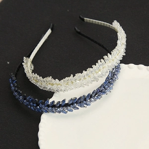 Gros plan de serre-têtes en cristal faits main en blanc et bleu marine avec perles taillées