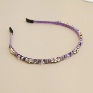 Détail d'un serre-tête en cristal violet fait main avec strass et perles élégantes