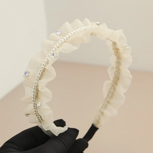 Dettaglio cerchietto in tulle crema con perle e strass a forma di cuore