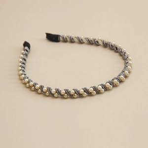 Detail of handmade pearl headband with silver metallic wire weaving and black fabric ends
